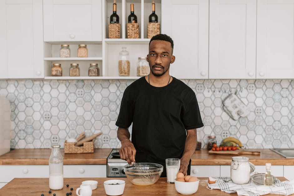 African American man preparing food in a modern kitchen with fresh ingredients.