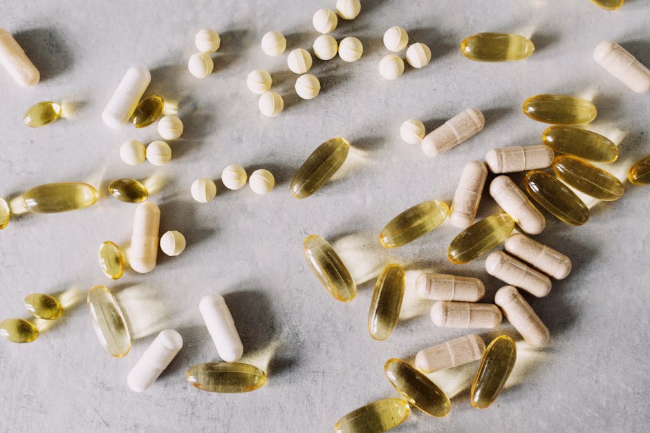 Various vitamins and supplements on a marble background, captured in flat lay style.