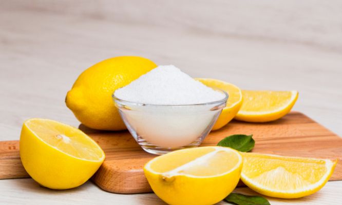 Lemons and a small bowl on a wooden board